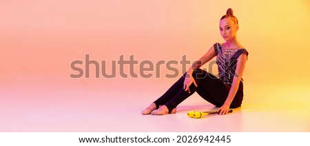 Flyer with young girl, rhythmic gymnastics artist in stage attire, sports costume isolated on pink yellow studio background in neon. Concept of sport, action, aspiration, education, active lifestyle.