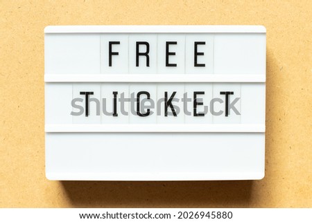 Lightbox with word free ticket on wood background