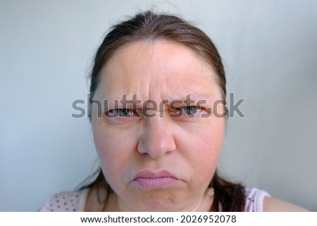 angry mad middle aged woman looks angrily, squints her eyes, face close up, emotional explosion from stress, female life, anger Royalty-Free Stock Photo #2026952078