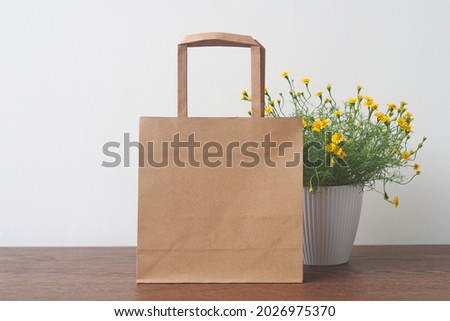 Blank brown paper bag on wooden table. Mockup for you designs.