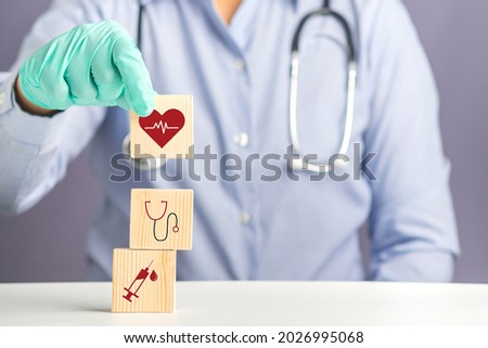 Hand of doctor arranging wood blocks with healthcare medical icons. Space for text. Health and medical concept.