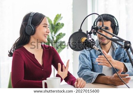 Smile two asian young woman, man radio hosts in headphones, microphone while talk, conversation, recording podcast in broadcasting at studio together. Technology of making record audio concept.