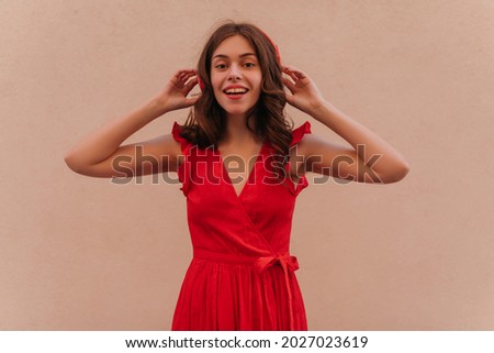 Hurray, the song of her favourite German artist started to play on the radio just yet. Young woman happy to hear it, they always dance with her sister while listening this song. Wearing red dress 