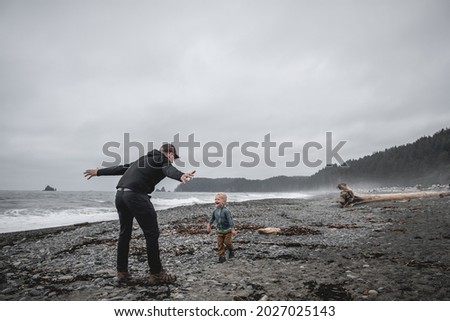 Father playing with son on Rialto Beach in Olympic National Park.