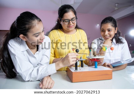 Teacher with students working with Planet  solar system  Royalty-Free Stock Photo #2027062913