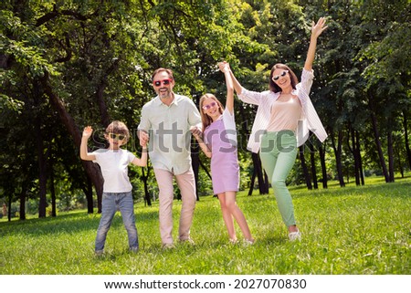 Full length body size view of attractive cheerful carefree family having fun on fresh air dancing enjoying outdoors