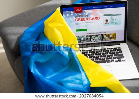 Green card in a search engine on the computer. laptop near the flag of ukraine
