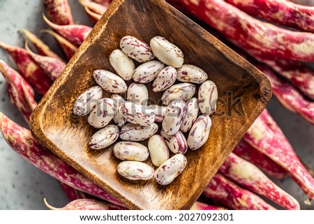 Cranberry beans in bowl. Beans pods. Top view.