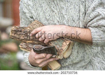 Male hands with wooden logs and axe. concept