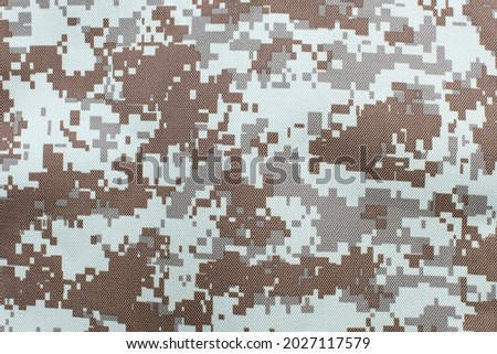 Textured durable fabric with a print of protective military clothing, close-up, in such clothing soldiers become almost invisible on the battlefield
