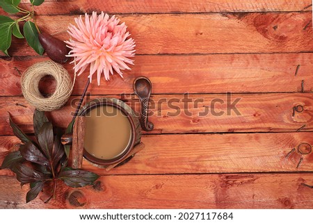 Autumn flower arrangement, abstract flat lay background with place for text, minimal holiday concept, thanksgiving day. Cup of hot coffee with cinnamon and seasonal flowers, rustic style