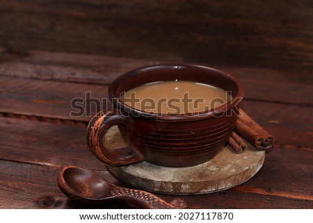 A cup of hot coffee with cinnamon in an old ceramic mug on a dark wooden background, close-up, low key, advertising of a bar or cafe, restaurant with a month for text, selective focus,