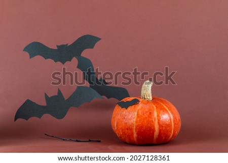 halloween picture with pumpkin and bat against brown background 