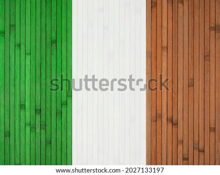 The national flag of Ireland is painted on the background of a wooden wall made of bamboo.