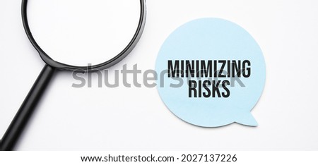minimizing risks speech bubble and black magnifier isolated on the yellow background.