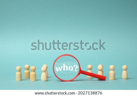 wooden figures of men stand on a blue background and a plastic magnifying glass. Recruitment concept, search for talented and capable employees, career growth