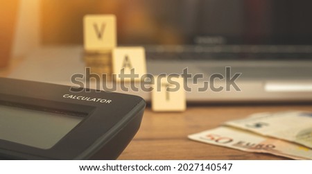 Calculating the VAT taxes in Europe, banner with VAT word and calculator on the business desktop with laptop