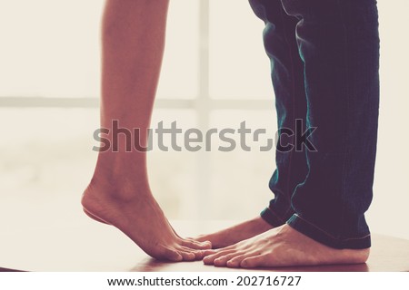 Close-up of legs of the kissing couple Royalty-Free Stock Photo #202716727
