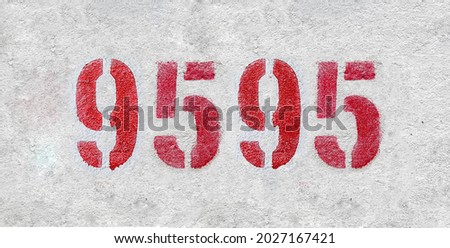 Red Number 9595 on the white wall. Spray paint. Number nine thousand five hundred ninety five.