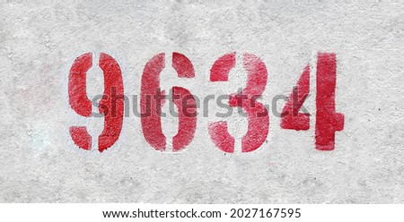 Red Number 9634 on the white wall. Spray paint. Number nine thousand six hundred thirty four.