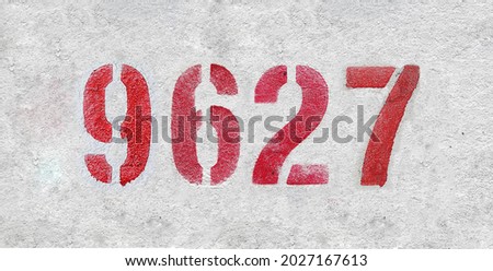 Red Number 9627 on the white wall. Spray paint. Number nine thousand six hundred and twenty seven.