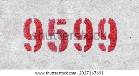 Red Number 9599 on the white wall. Spray paint. Number nine thousand five hundred ninety nine.