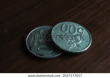 two 500 old rupiah coins, a sign of save