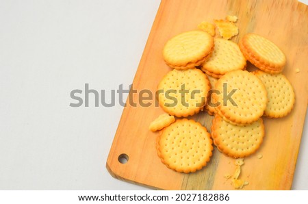 pile of biscuits placed on a wooden cutting board, photo from the top corner, isolated on a white background