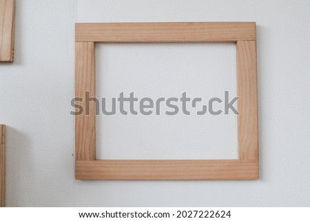 Wooden frame on white wall. Interior of living room with mock up photo frames. Design home decoration.