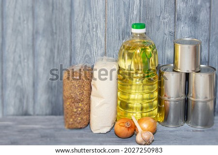 canned food and various cereals on a wooden shelf, food crisis.