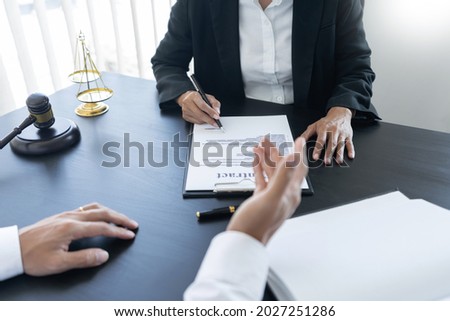 law,libra scale and hammer on the table, 2 lawyers are discussing about contract paper, law matters determination, open hand.