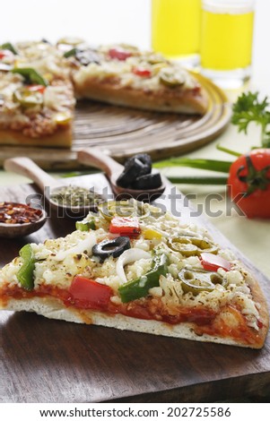  Close up of Pizza triangle shape, with mozzarella cheese and several ingredients on it and cut pizza at background