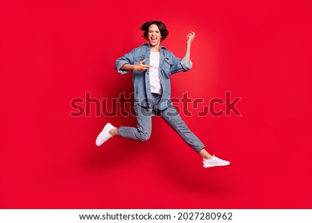 Full size photo of young woman happy positive smile play guitar jump isolated over red color background