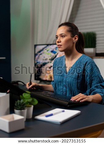 Creative editing artist using retoucher software on photo sitting at desk while working with photography editing equipment. Young woman retouching project on desktop monitor computer