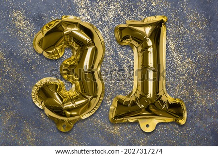 The number of the balloon made of golden foil, the number thirty-one on a gray background with sequins. Birthday greeting card with inscription 31. Numerical digit, Celebration event, template.
