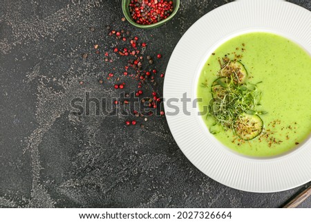 Plate with green gazpacho on dark background