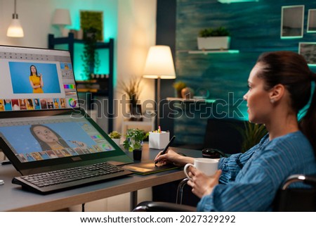 Creative photographer doing retouch work on image using professional modern equipment digital tablet stylus at agency studio. Retouching artist woman working on photo editing project