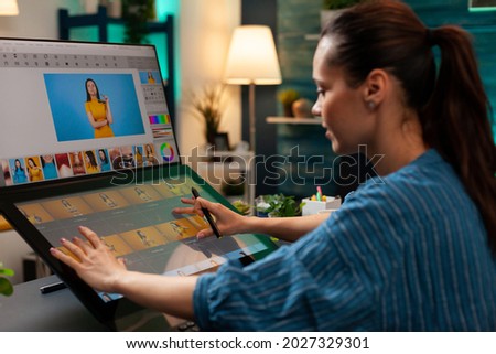 Professional editor doing retouching work on image for design project at office. Graphic artist woman working with touchpad monitor computer and modern digital production equipment