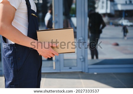 Postman with parcel box. Postal delivery service.