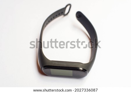 Small black smart watch on isolated white background.
