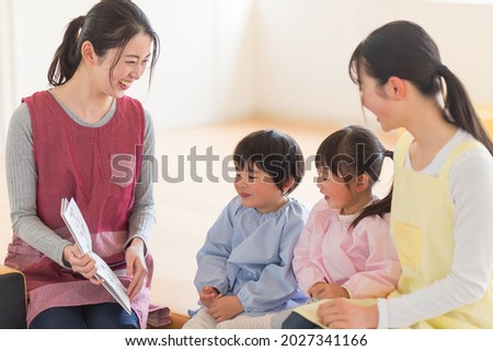 Nursery teacher reading aloud to children