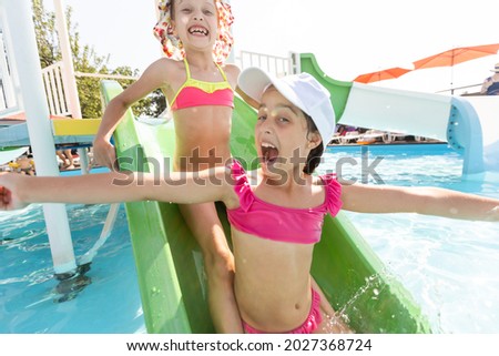 Happy children in the swimming pool. Funny kids playing outdoors. Summer vacation concept.