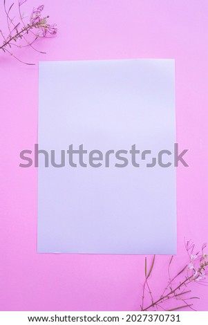 A4 White Paper On Pastel Pink Background With Floral Decoration. Vertical Photo, White Paper. Paper Mockups. Pastel Color Background
