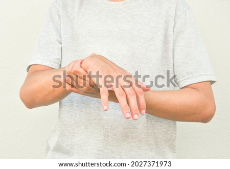 a man support his hand and arm that having symptoms of pain,numbness,weakness,paralysis,muscle disorder, concept of Guillain barre syndrome caused by autoimmune disorder Royalty-Free Stock Photo #2027371973