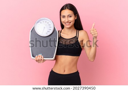 hispanic pretty woman with a scale. diet concept
