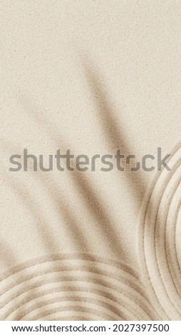 Zen garden meditation sandy background for relaxation. Lines drawing in sand and shadows of palm leaves. Concept of harmony, meditation, spa, relax. Vertical format for stories.