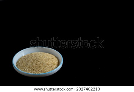  Mysuru,Karnataka,India-August 19 2021; A Close up picture of Poppy seeds in a white bowl isolated on a black background in food photography.
