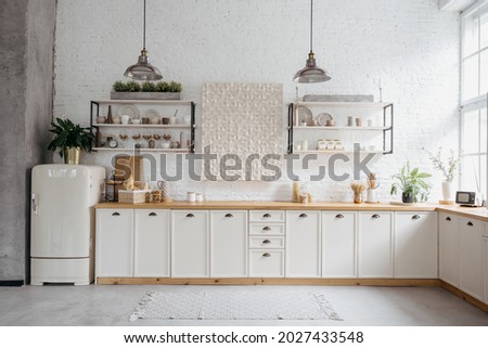 Rustic kitchen interior with white brick wall. Modern room design with wooden furniture, cozy home with vintage decoration. Tabletop with food, shelves with ceramic kitchenware.