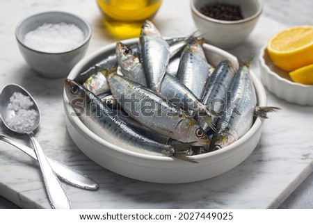 Fresh sardines, lemon and salt on kitchen, close up shot Royalty-Free Stock Photo #2027449025