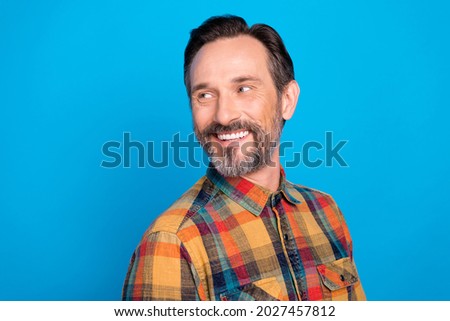 Photo of funny brunet hairdo age man look empty space wear plaid shirt isolated on blue color background